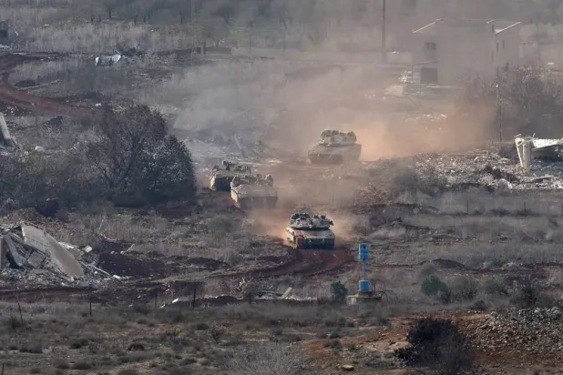 Israeli troops move between destroyed houses, in the south Lebanon village of Mais al-Jabal, as seen from the Israeli side of the border, 04 December 2024. (EPA)