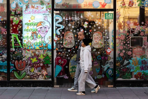 مشاة في أحد الشوارع التجارية بمدينة شنغهاي الصينية (إ.ب.أ)