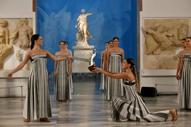 Greek actress Mary Mina (L), playing the role of the High Priestess, takes part in the flame lighting ceremony of the Olympic flame, for the Olympic Winter Games Milano Cortina 2026, at the Museum of ancient Olympia, in Olympia on November 26, 2025. (AFP)