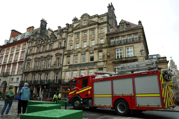 سيارة إطفاء متوقفة بالقرب من موقع الحادث الذي اصطدمت فيه سيارة بحشد من مشجعي ليفربول أثناء مسيرة للاحتفال بلقب الدوري الإنجليزي الممتاز لكرة القدم في وسط ليفربول - بريطانيا 28 مايو 2025 (رويترز)