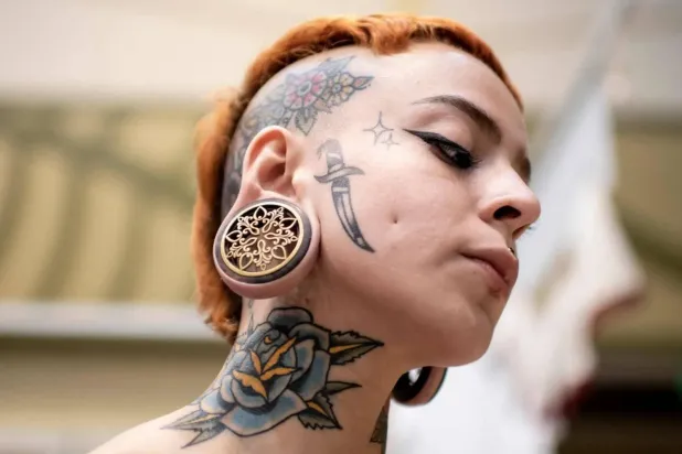 يتعامل الجسم مع حبر الوشم على أنه مادة غريبة مما يحفز جهاز المناعة (أ.ف.ب)