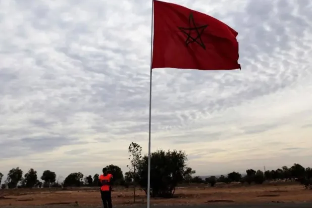 File photo of a police officer standing near a Moroccan national flag near the main stadium during preparations for the FIFA Club World Cup in Agadir, December 10, 2013. REUTERS/Amr Abdallah Dalsh
