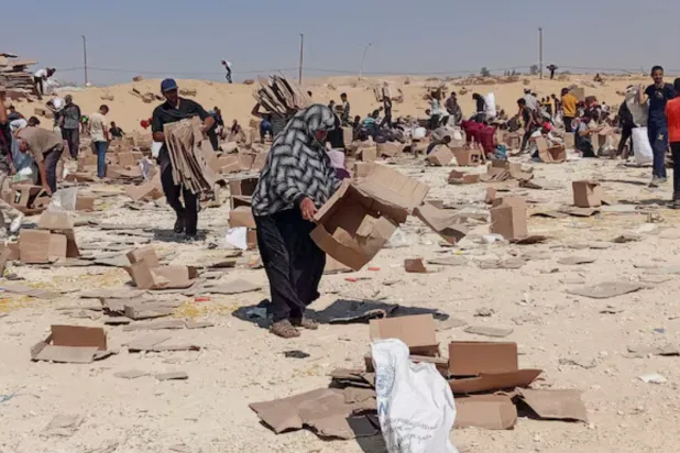 Palestinians gather to collect what remains of relief supplies from the distribution center of the US-backed Gaza Humanitarian Foundation, in Rafah, in the southern Gaza Strip, June 5, 2025. REUTERS/Stringer/File Photo 
