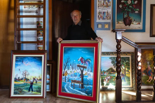 Painter Pavel Hajko poses with his work at his home studio northern Serbia. Andrej ISAKOVIC / AFP
