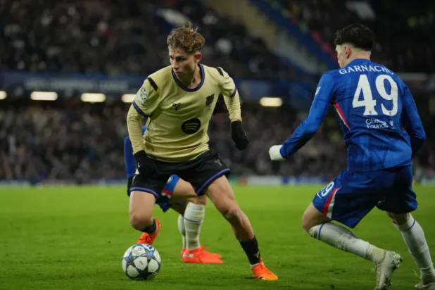 Barcelona’s Fermin Lopez, left, runs with the ball past Chelsea’s Alejandro Garnacho during the Champions League opening phase soccer match between Chelsea and Barcelona in London, Tuesday, Nov. 25, 2025. (AP Photo/Kin Cheung)

