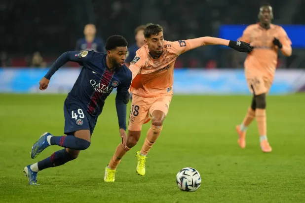 PSG's Ibrahim Mbaye, left, challenges for the ball with Le Havre's Yanis Zouaoui during the French League One soccer match between Paris Saint Germain and Le Havre in Paris, France, Saturday, Nov. 22, 2025. (AP Photo/Aurelien Morissard)