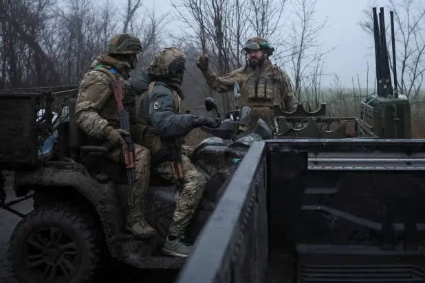 جندي أوكراني يتحدث مع زملائه العسكريين أثناء عودتهم في عربة عسكرية بعد مهمة قتالية بالقرب من بلدة كوستيانتينيفكا على خط المواجهة في منطقة دونيتسك بأوكرانيا يوم 27 نوفمبر 2025 (رويترز)