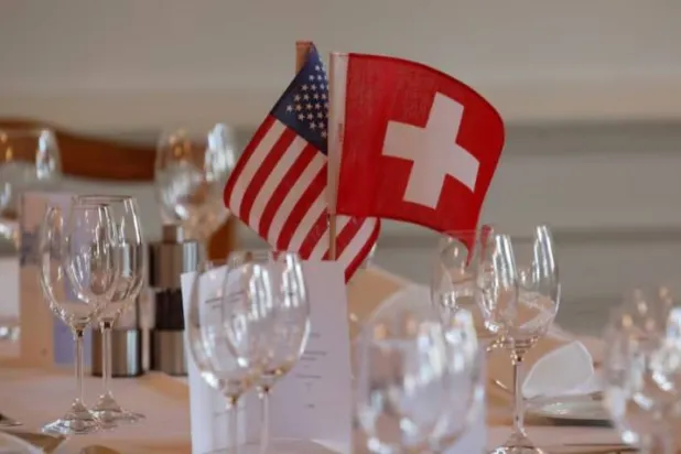 علَما الولايات المتحدة وسويسرا موضوعان على الطاولات قبل فعالية لغرفة التجارة السويسرية -الأميركية في زيوريخ (رويترز)