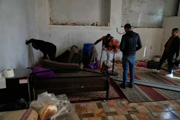 فلسطينيون يتفقدون المكان الذي قُتل فيه المنتصر بالله عبد الله ويوسف عصاعصة في جنين (أ.ب)