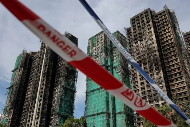  Police cordons are placed at the scene of the Wang Fuk Court housing estate fire as mourners pay tribute to the victims, in Tai Po, Hong Kong, China, November 28, 2025. (Reuters)