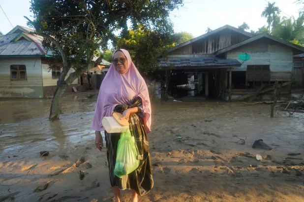 امرأة أثناء زيارتها لمنطقة ضربتها فيضانات مفاجئة مميتة عقب هطول أمطار غزيرة في منطقة بيروين (رويترز)