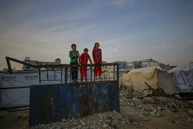 Gazze Şehri'nde yıkılan binaların enkazı arasında, yerinden edilmiş Filistinli çocuklar ailelerinin barınaklarının yakınında oynuyor (EPA)