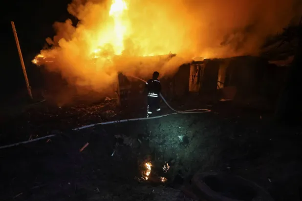 رجل إطفاء يعمل في موقع غارة بطائرة من دون طيار في خاركيف (رويترز)