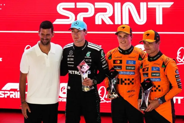  Race winner McLaren driver Oscar Piastri of Australia, second right, poses with second placed Mercedes driver George Russell of Britain, second left, third placed McLaren driver Lando Norris of Britain, right, and Serbian tennis player Novak Djokovic after the sprint race at the Lusail International Circuit ahead of the Qatar Formula One Grand Prix, in Lusail, Qatar, Saturday, Nov. 29, 2025. (AP) 