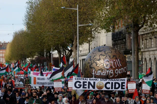 متظاهرون يرفعون أعلام فلسطين ويطالبون بوقف تمويل الإبادة في غزة خال مسيرة بيوم التضامن الدولي مع الشعب الفلسطيني في دبلن (رويترز)  