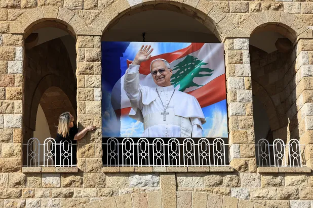 FILE PHOTO: A woman stands next to a poster depicting Pope Leo XIV at De La Croix Psychiatric Hospital in Jal el-Dib, Lebanon November 19, 2025. REUTERS/Mohamed Azakir/File Photo