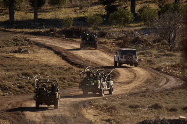 Israeli armored vehicles conduct a maneuver in the buffer zone after crossing the security fence near the demarcation line between the occupied Golan Heights and Syria last December (AP).