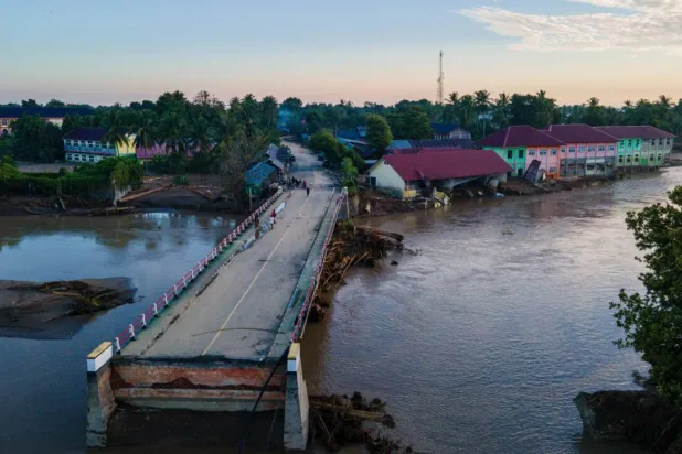 A bridge damaged by flash floods is seen during sunrise in Meureudu, Pidie Jaya district in Indonesia's Aceh province on November 30. CHAIDEER MAHYUDDIN / AFP
