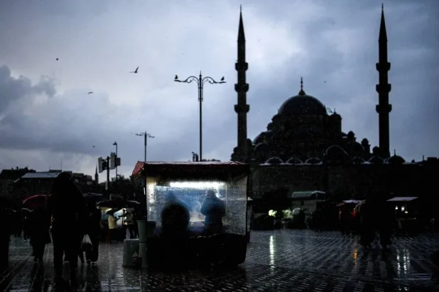Vendors sell roasted chestnuts near the New Mosque in a rainy day in Istanbul, Türkiye, Sunday, Nov. 30, 2025. (AP) 