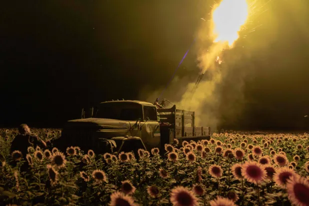 Ukrainian servicemen of the 59th brigade mobile air defence unit fire a Soviet made ZU-23 anti-aircraft twin autocannon towards a Russian drone from a sunflower field, during an air attack near Pavlograd, Dnipropetrovsk region on July 19, 2025, amid the Russian invasion of Ukraine (Photo by Roman PILIPEY / AFP) / AFP PICTURES OF THE YEAR 2025