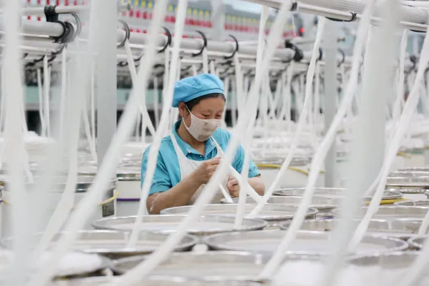 عاملة في مصنع للنسيج بمدينة بينتشو شرق الصين (أ.ف.ب)