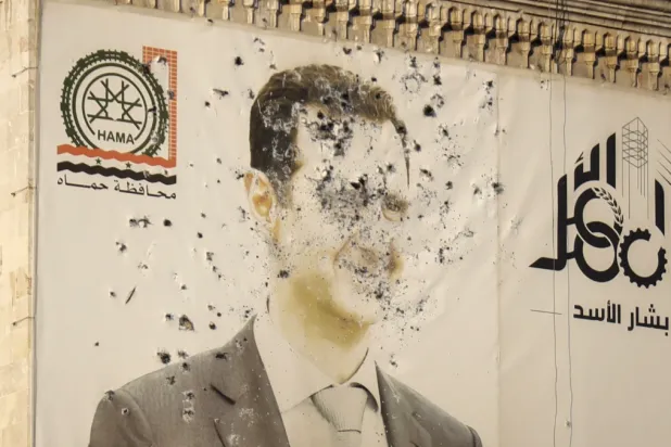 An image of Syrian President Bashar Assad, riddled with bullets, is seen on the facade of the provincial government office in the aftermath of the opposition’s takeover of Hama, Syria, Friday, Dec. 6, 2024. (AP Photo/Omar Albam)
