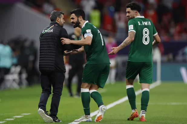 عمر خربين وزميله سيمون أمين يحتفلان بهدف الفوز على تونس (رويترز)