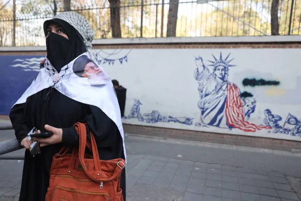 A woman stands next to an anti-US mural during the 46th anniversary of the US expulsion from Iran, in Tehran, November 4, 2025. Majid Asgaripour/WANA (West Asia News Agency) via REUTERS