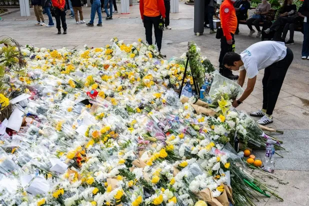 People offer flowers for the victims near the site of a deadly fire at Wang Fuk Court, a residential estate in the Tai Po district of Hong Kong's New Territories on Tuesday, Dec 2, 2025. (AP)