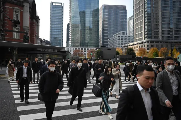 مشاة يعبرون تقاطعاً للطريق وسط العاصمة اليابانية طوكيو (أ.ف.ب)
