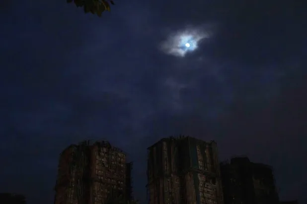  The moon rises over the site of a deadly fire at Wang Fuk Court, a residential estate in the Tai Po district of Hong Kong's New Territories, on Tuesday, Dec. 2, 2025. (AP Photo/Ng Han Guan)