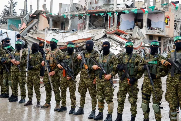 Palestinian Hamas fighters stand guard on the day of the handover of hostages held in Gaza since the deadly October 7 2023 attack, as part of a ceasefire and a hostages-prisoners swap deal between Hamas and Israel, in Rafah in the southern Gaza Strip, February 22, 2025. REUTERS