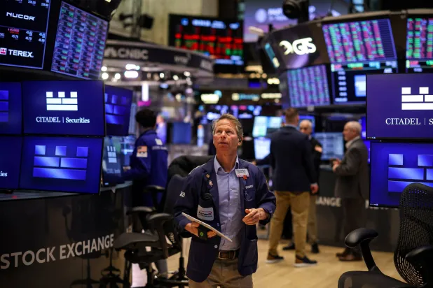 متداول يقف وسط بورصة نيويورك (رويترز)
