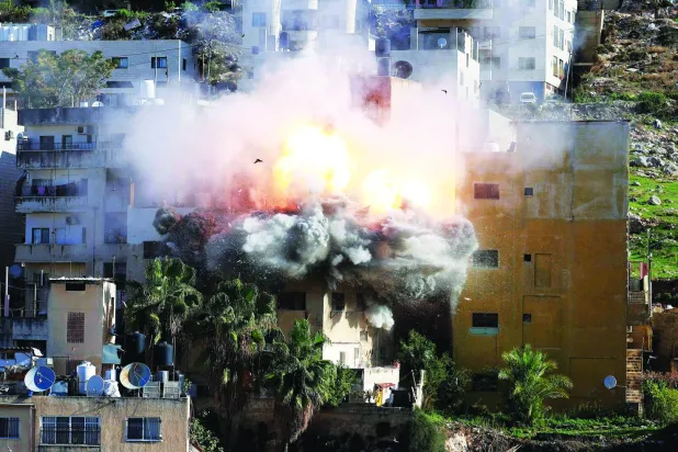 لحظة تفجير منزل الفلسطيني المعتقل عبد الكريم صنوبر في نابلس بالضفة الغربية بعد أن فجّرته قوات إسرائيلية أمس (أ.ف.ب)