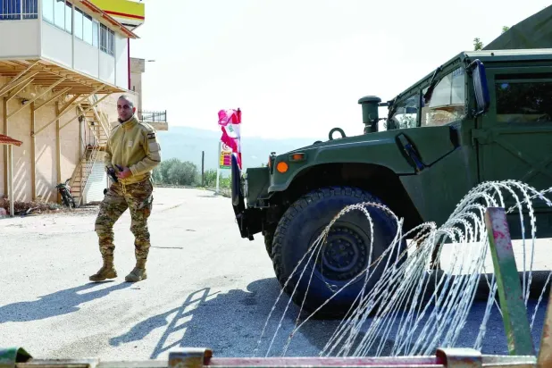 A Lebanese soldier stands beside a military vehicle in the southern town of Deir Mimas (Reuters)