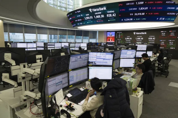 متداولون كوريون جنوبيون يعملون أمام شاشات في بنك هانا بسيول (إ.ب.أ)
