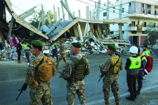 جنود من الجيش اللبناني أمام مبنى استُهدف بغارة جوية إسرائيلية في قرية دير كيفا جنوب لبنان الشهر الماضي (أ.ف.ب)