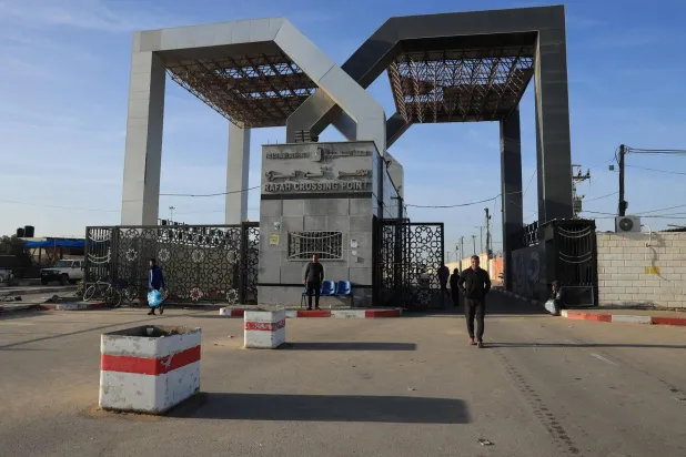 People stand in front of the Palestinian side of the Rafah crossing during the first hours of a four-day truce in the battles between Israel and Hamas on November 24, 2023. (AFP)