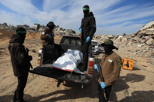 مسلحون من حركتي «حماس» و«الجهاد» يعثرون على جثة خلال عملية البحث عن جثث الرهائن القتلى في بيت لاهيا شمال قطاع غزة (رويترز)