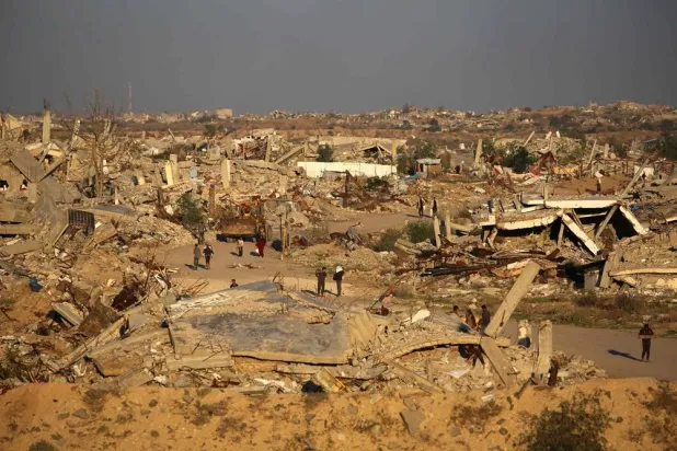 People walk amid the rubble of destroyed buildings in the Nuseirat camp for displaced Palestinians, in the central Gaza Strip on December 2, 2025. (AFP) 