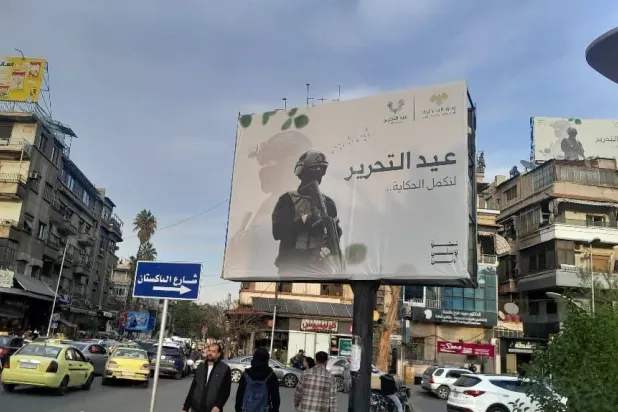 من لافتات ذكرى التحرير وسقوط نظام الأسد في شوارع دمشق (الشرق الأوسط)