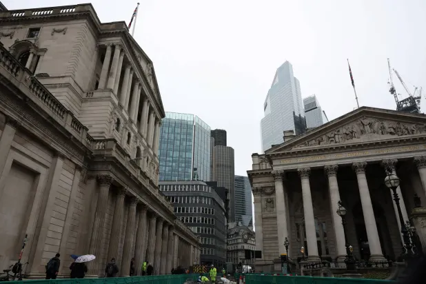 عمال إنشاء الطرق يؤدون أعمالهم خارج بنك إنجلترا في منطقة سيتي المالية بلندن (رويترز)