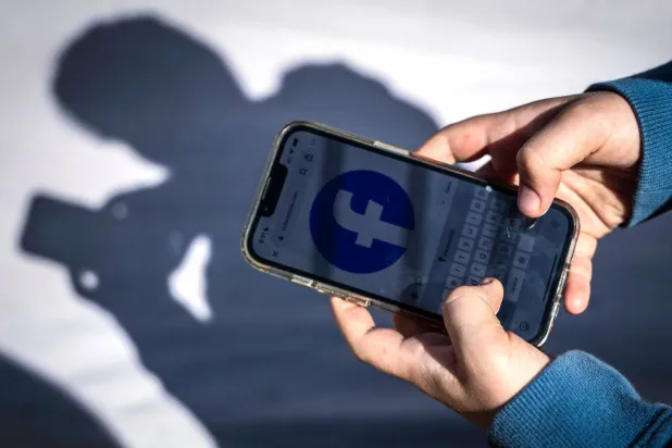 (FILES) This photo taken on October 24, 2025 shows a 14-year-old boy posing at his home near Gosford as he looks at social media on his mobile phone. (Photo by David GRAY / AFP)