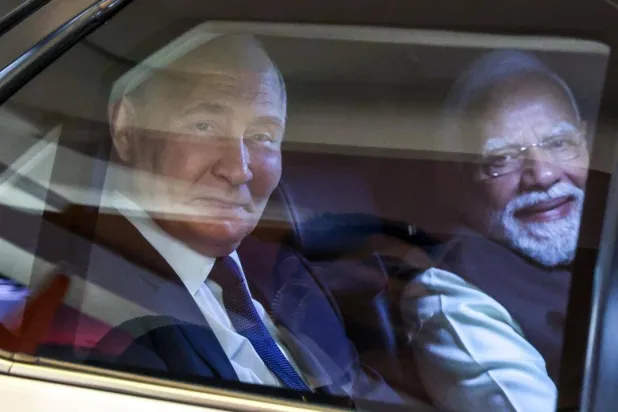 In this pool photograph distributed by the Russian state agency Sputnik, Russia's President Vladimir Putin and Indian Prime Minister Narendra Modi look out from a car prior to an informal dinner at Modi's residence. Alexander KAZAKOV / POOL/AFP 