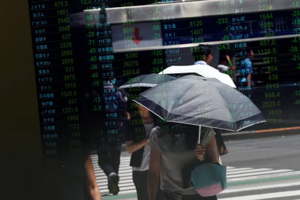 انعكاس المتداولين على لوحة أسعار الأسهم في طوكيو (رويترز)