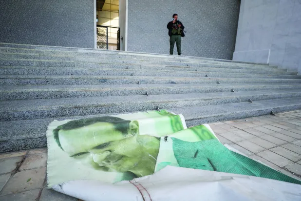 A poster of Bashar al-Assad is seen on the ground at the presidential palace in Damascus after he fled Syria on December 8, 2024. (AP) 