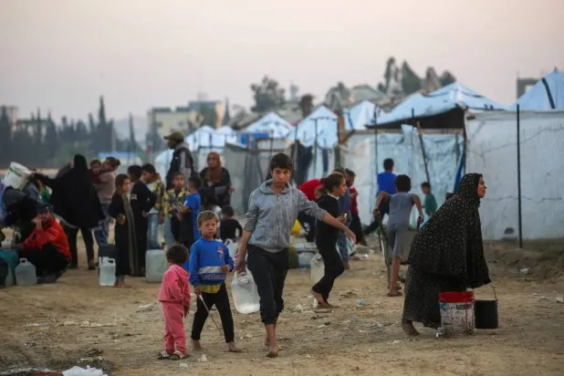 Palestinians fill water containers at the Nuseirat camp for displaced families in central Gaza (AFP)