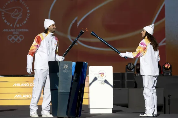 Italy's high jump athlete and torchbearer Gianmarco Tamberi (L) and Italy's former fencing athlete Elisa Di Francisca light the torch with the Olympic flame during the Torch Relay to Milano-Cortina 2026 Olympic Games, in Rome, Italy, 06 December 2025.  EPA/MASSIMO PERCOSSI