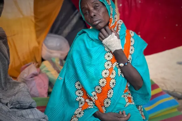 Sudan'ın Faşir kentinde çıkan çatışmada yaralanan ve Tavile Mülteci Kampı’ndaki çadırında oturan Sudanlı bir kadın (AP)