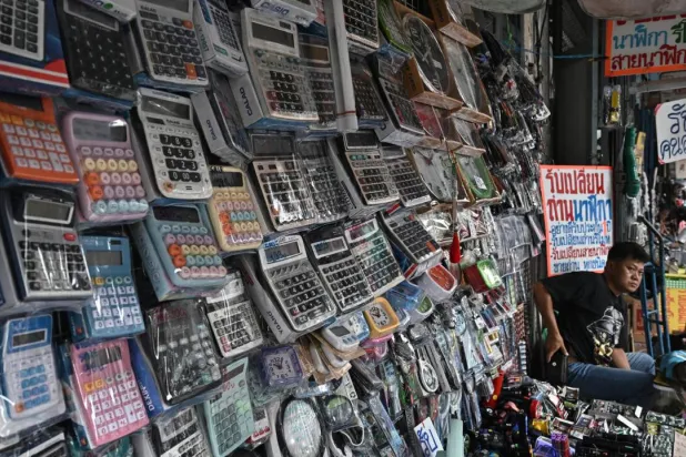 Calculators are more affordable than phones, and run on batteries and solar power. Lillian SUWANRUMPHA / AFP
